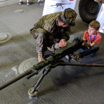 Kid learning to shoot a big gun